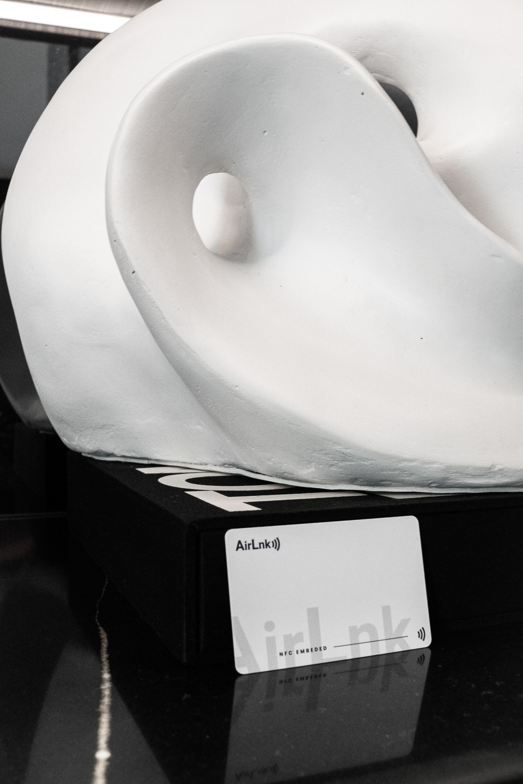 White AirLnk Smart Card resting against a white sculpture