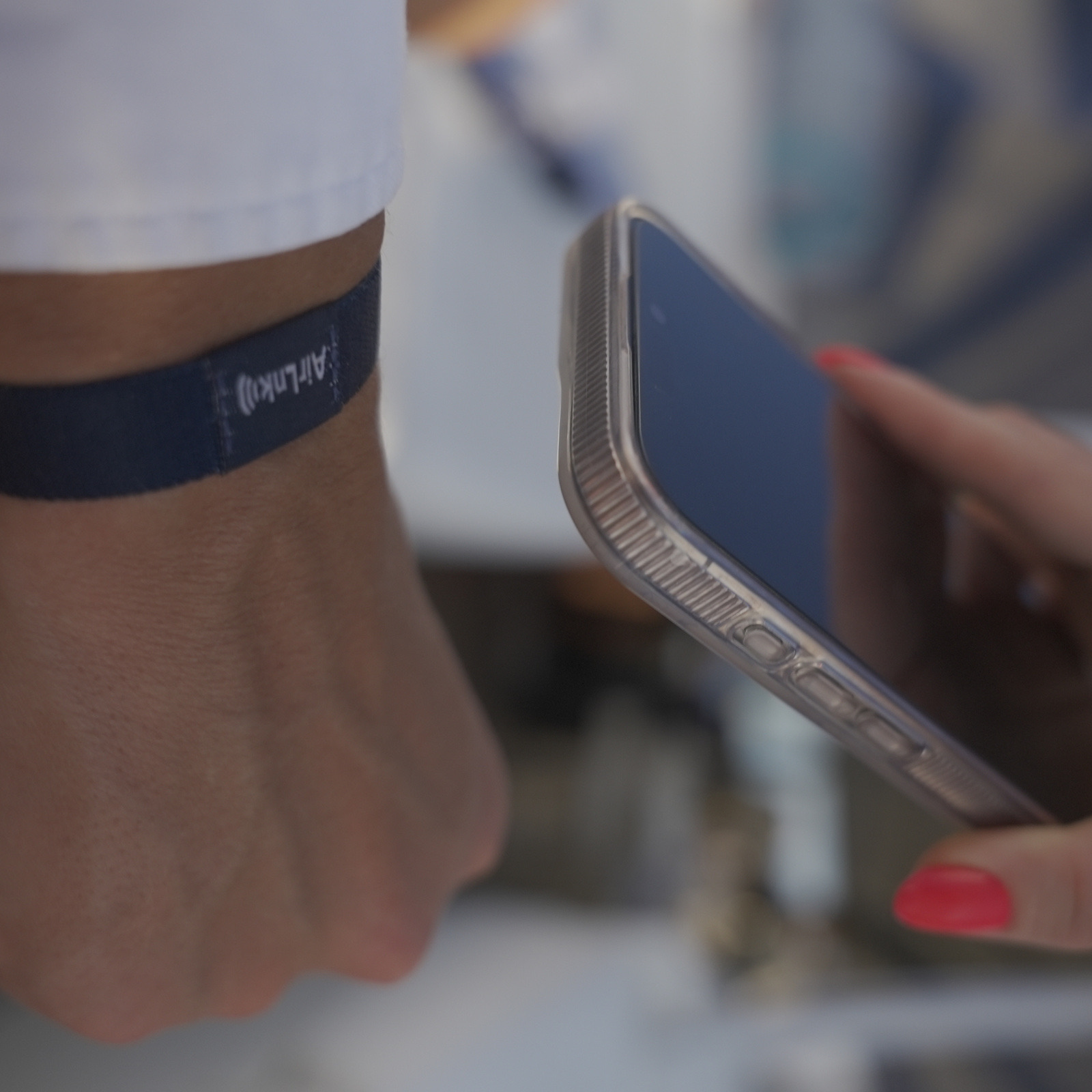A phone tapping an AirLnk wristband